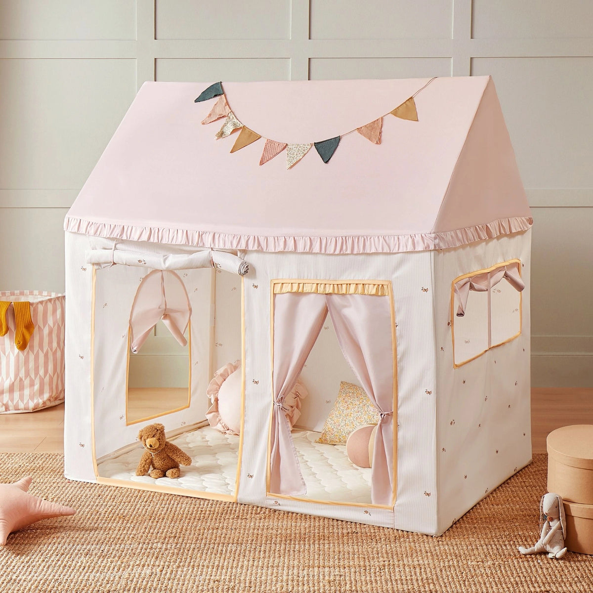 The Tiny Land® Sweet Citrus Kids Play Tent by Tiny Land features a white and pink house-shaped design with pastel bunting, window flaps, and a padded floor—perfect for indoor or outdoor play in any bright, child-friendly space.