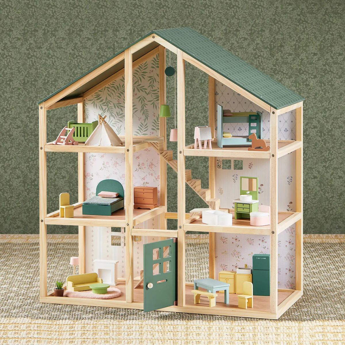 The Tiny Land® Sweetwood Evergreen Dollhouse by Tiny Land features six furnished rooms with an open front, miniature furniture and accessories, green patterned wallpaper, and a woven rug. Dolls are not included.